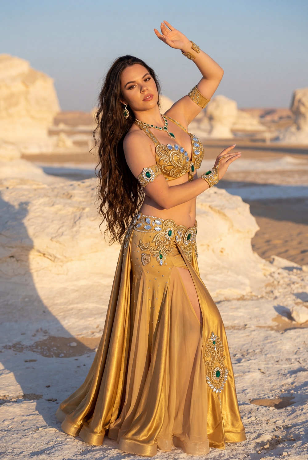 Dancer robed in gold among the white rock of the desert