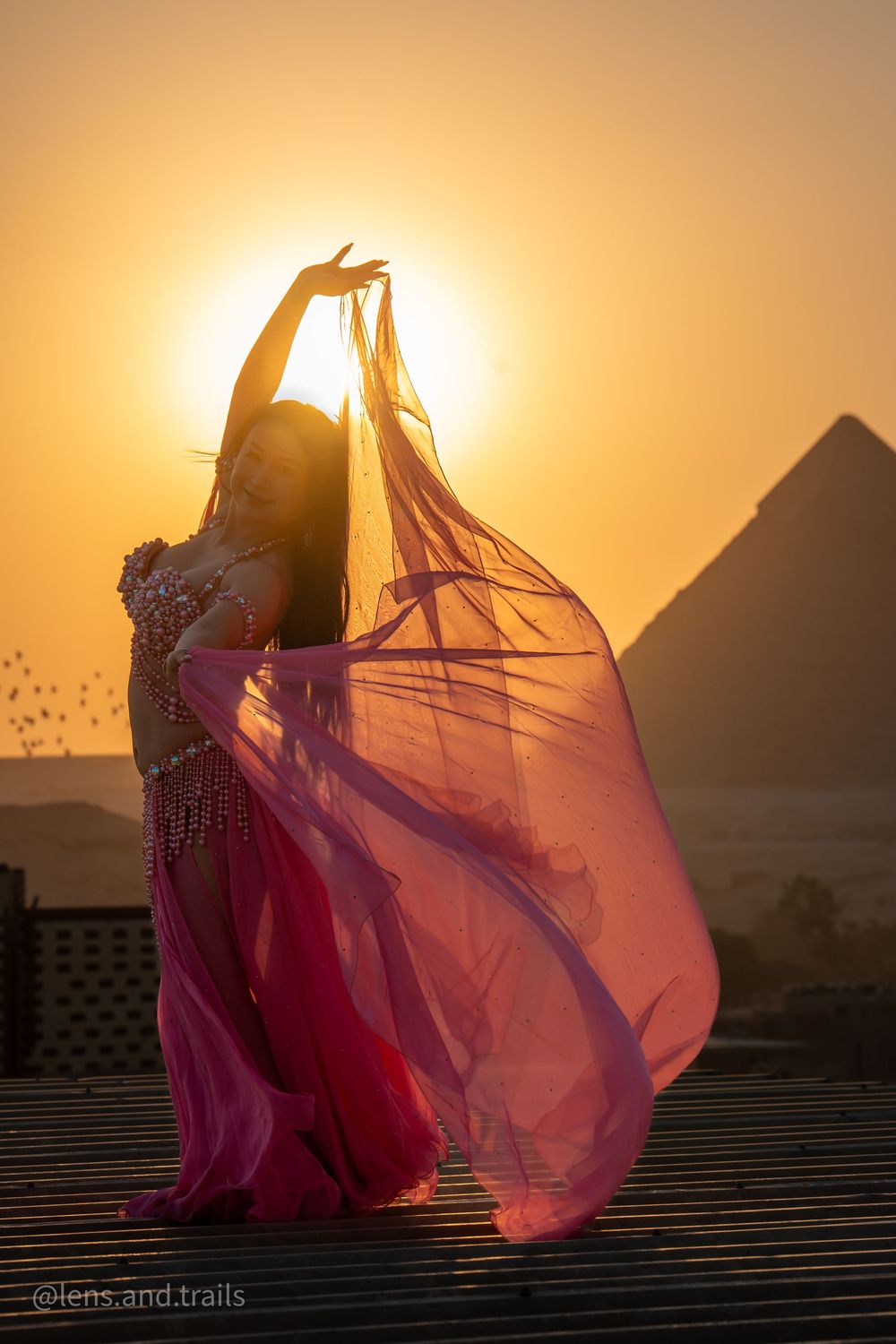 Bellydancer with a pink silk veil before the Great Pyramid at sunset